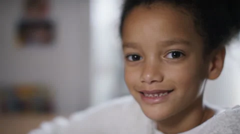 Young girl smiles to camera whilst using color pens in her book Video stock 59556540