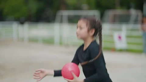 Young girl smiles while playing with a pink ball Stock Footage 340448777
