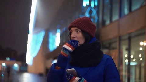 Young girl smiling using smartphone watching video. Knitted mittens on her hands Stock-Footage 83070621