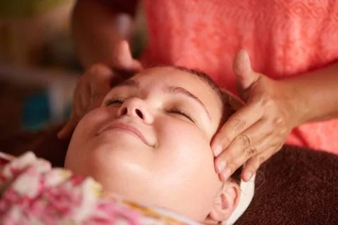 Young girl smiling while getting a massage, during her facial, from her local Stock Photos
