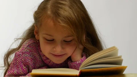 Young girl smiling while reading book Stock-Footage 82804412