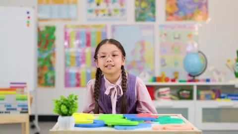 Young Girl Solving Math Problems in Colorful Classroom Setting Stock Footage 321450237