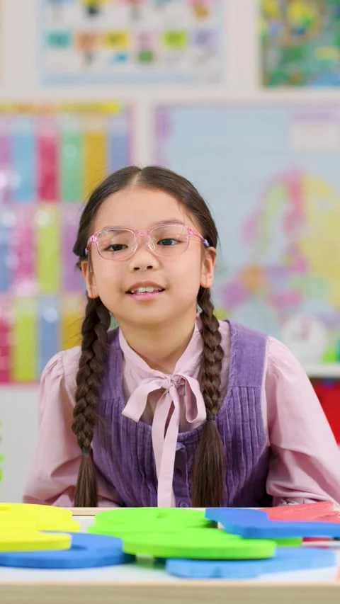 Young Girl Solving Math Problems in Colorful Classroom Stock Footage 325164854