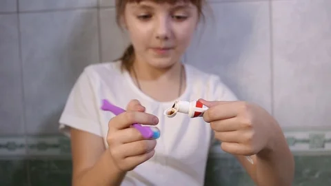 Young girl squeezes toothpaste on brush. Health care, hygiene, caries prevention Stock Footage 118854047