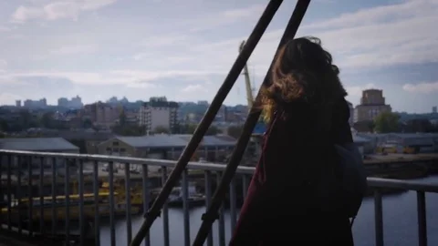 The young girl is strolling through the abandoned bridge observing the old harbo 스톡 동영상 80965555