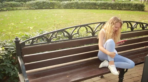 Young girl with a suitcase writes messages on the phone Stock Footage