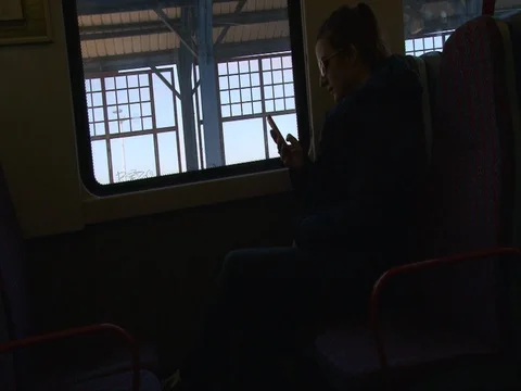 Young girl in sunglasses using mobile smart phone in the train or bus Stock Footage 74135330