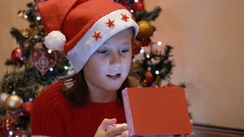 Young girl is surprised while opening the carillon in Christmas Stock Footage 141044106