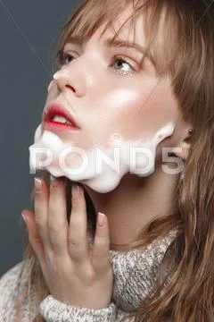 Young girl in sweater with foam beard Stock Photos