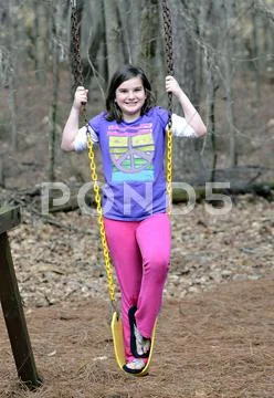 Young girl on swing outdoors Stock Photos
