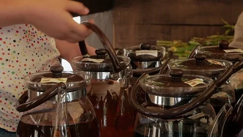 Young girl takes a glass teapot with tea Stock Footage