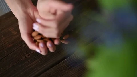 Young girl taking almonds from the table Stock Footage 74660899