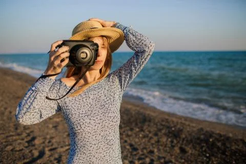 Young girl taking pictures at the beach. Stock Photos
