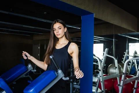 Young girl trainer performs exercise in modern gym club Stock Photos