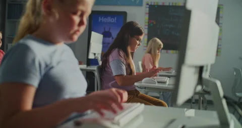 Young Girl Typing on Computer Keyboard In Sunlit Classroom Stock Footage 318069573