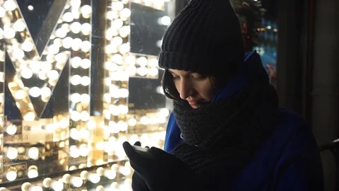Young girl typing message using smartphone on a busy urban street in evening Stock Footage 83874259