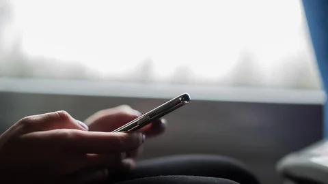 Young girl typing messages using smartphone in train. Close-up of hands. Stock Footage 81356780