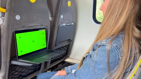 A young girl uses a laptop while traveling on a train. Using a laptop while Stock Footage 253174629