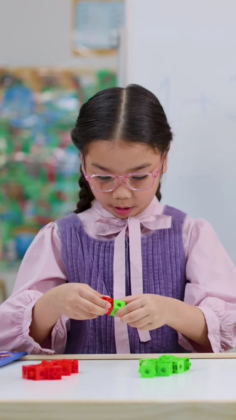 Young Girl Using Colorful Math Cubes for Learning in Classroom Stock Footage 327770884