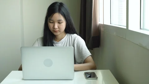 Young girl using computer laptop for doing her homework at home  Stock Footage 107733499