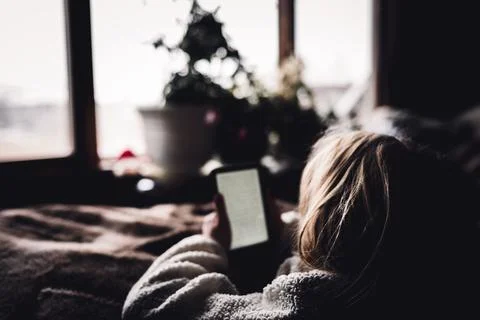 Young girl using an e-reader tablet to enjoy a book. Foto stock