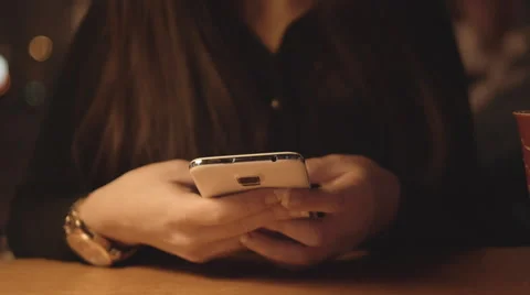 Young girl using her mobile phone in Cafe in the Evening 4K Stock Footage 46596134
