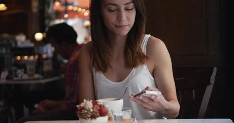 Young girl using her mobile phone sending texts in Cafe 4K Stock Footage 51685006