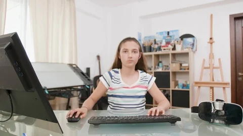 Young girl using her mouse and keyboard to type a text facing the camera Stock Footage 107585827