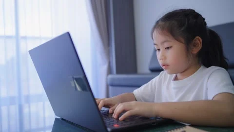 Young Girl Using Laptop Computer at Home, Learning and Playing, Focused Chi.. Stock Footage 337527318