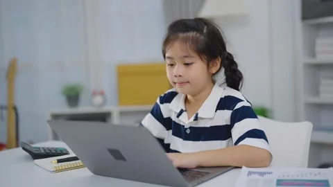 Young girl using laptop computer indoors at home with notebook calculator a.. Stock Footage 348163721