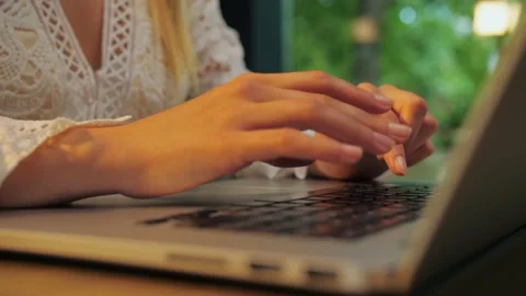 Young girl using laptop sitting in a restaurant. working at her computer in  Stock Footage 202479113