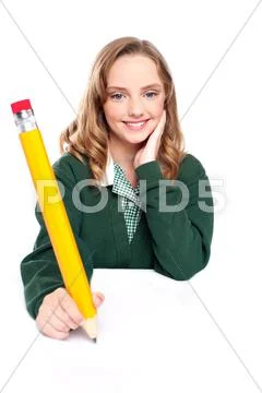 Young girl using an over sized pencil Stock Photos