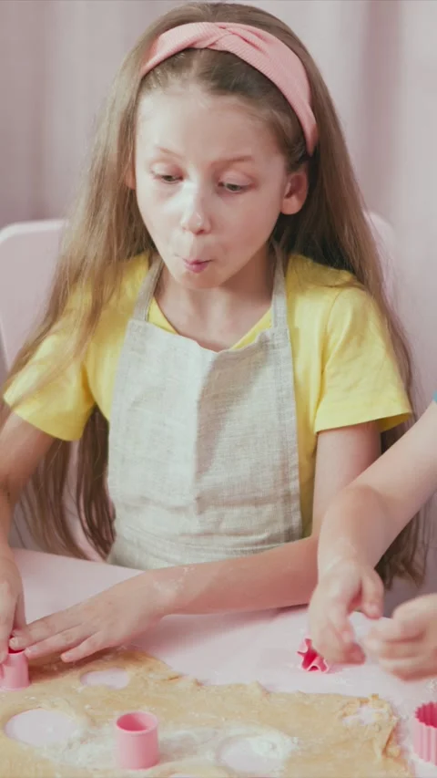 Young Girl Using Pink Cookie Cutters to Shape Dough Assisted by Another Child in Stock Footage 345983834