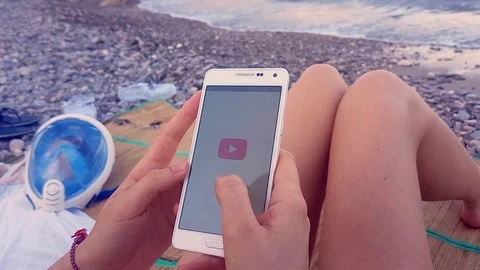 Young Girl Using a Smartphone on the Beach Stock-Footage 79285349