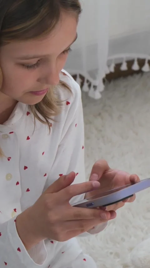 Young girl using smartphone while sitting on carpet home. Stock Footage 331659251