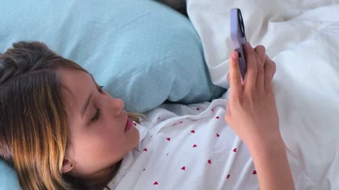 Young girl using smartphone while  lying in her bed. Stock Footage 331659325