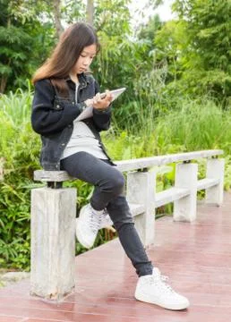 A young girl using tablet computer in park Stock Photos
