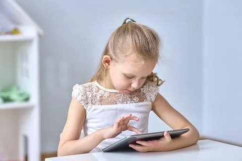 Young Girl Using Tablet in Focused Engagement Stock Photos