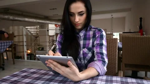 Young girl using tablet pc in the restaurant. Stock Footage 61407834