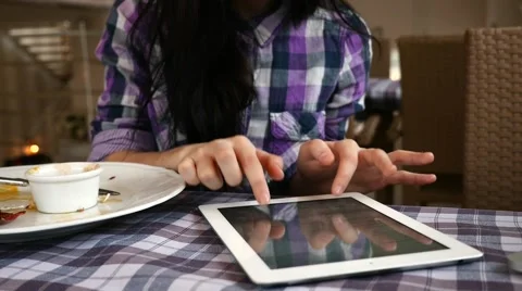 Young girl using tablet pc in the restaurant. She just finished her breakfast Video stock 61408274