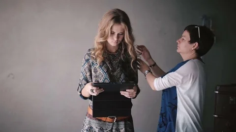 Young girl using a tablet PC while it is being prepared for photo shoot Stock Footage 70311486
