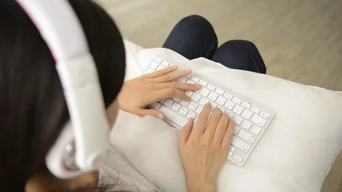 Young girl using wireless keyboard on the couch Video stock 93629774