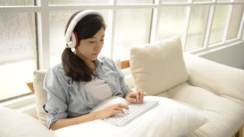 Young girl using wireless keyboard on the couch Stock-Footage 93629923