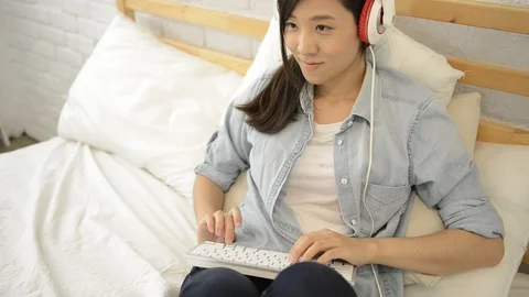 Young girl using wireless keyboard on the bed Stock-Footage 93632141