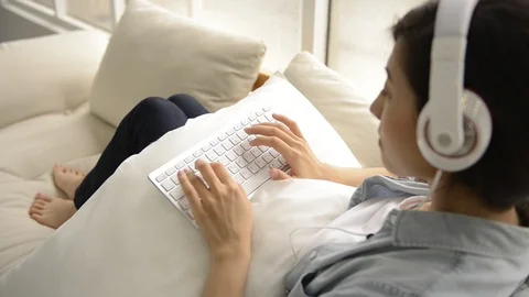 Young girl using wireless keyboard on the couch Vidéo 93651610