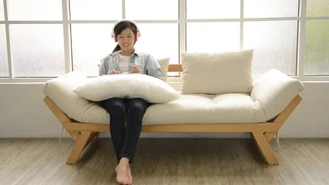 Young girl using wireless keyboard on the couch Stock-Footage 93651627