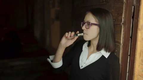 Young girl vaping e-cig vaporizer device, in  cafe Video stock 95948002