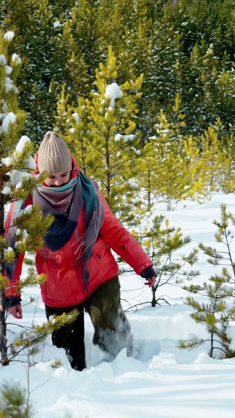 A young girl walking through deep snow in a snowy forest. Stock Footage 345014510