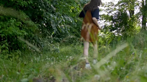 Young girl walking through a path in nature in brown clothes Stock Footage 112282076