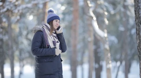 Young girl walking in the winter woods and talking on the phone Stock Footage 59658215
